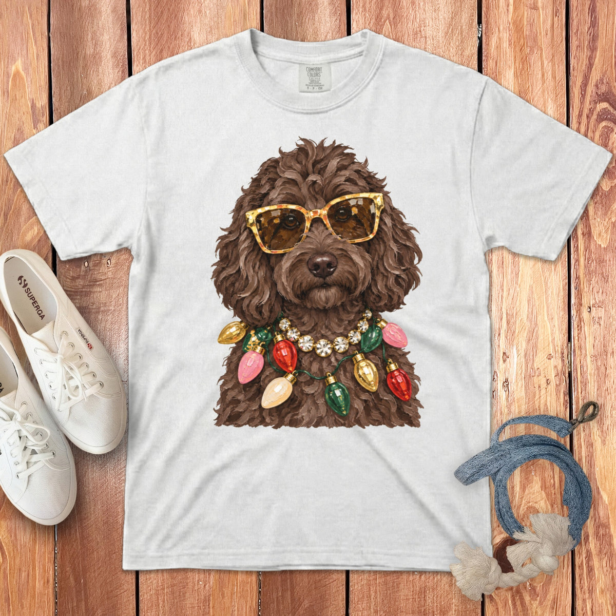 White t-shirt featuring brown dog wearing sunglasses and Christmas lights necklace.
