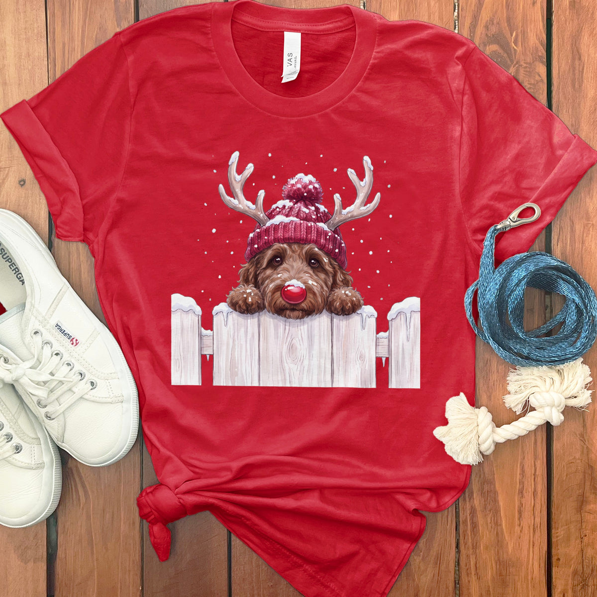 Red t-shirt with a doodle dog wearing antlers, a knitted hat, and a red nose.