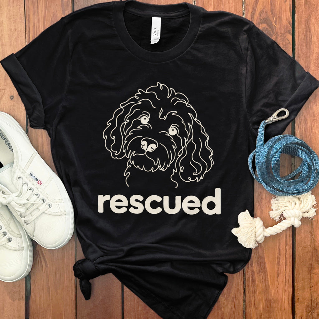 Black t-shirt with a white line drawing of a dog and the word "rescued".