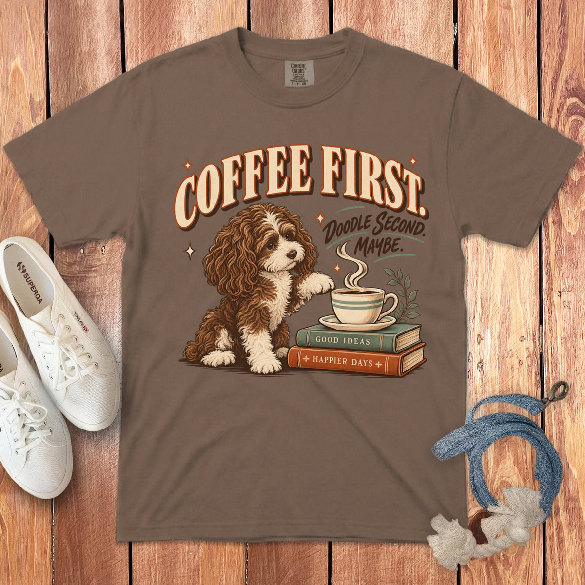 Brown t-shirt featuring a cartoon doodle dog graphic with text reading Coffee First, Doodle Second, Maybe.