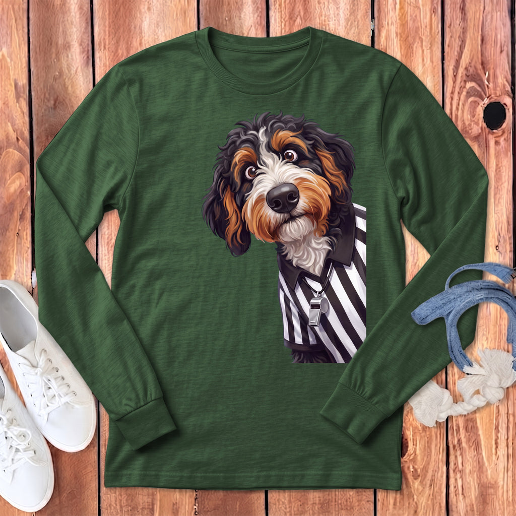 Bernese Mountain Dog wearing a referee shirt and whistle on a green long-sleeve shirt.