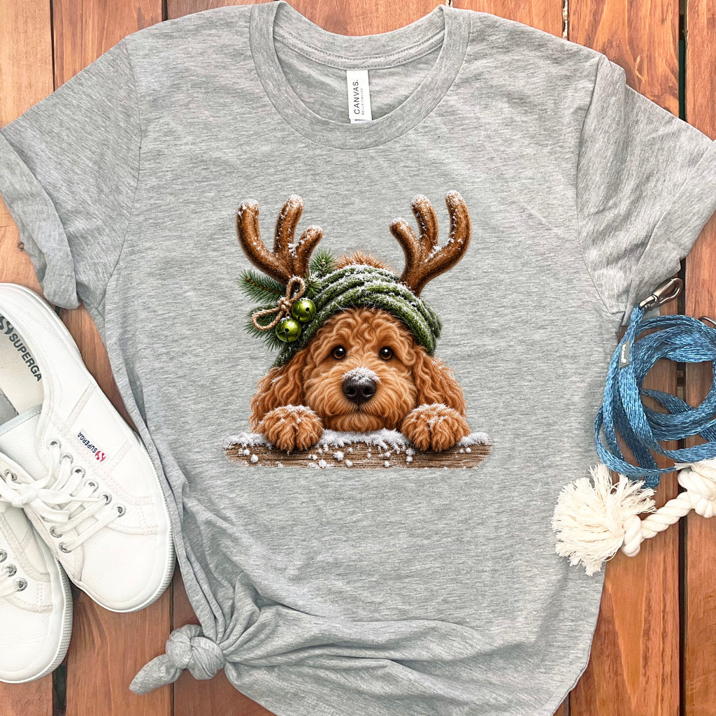 Grey t-shirt with a doodle dog wearing reindeer antlers and a green beanie.