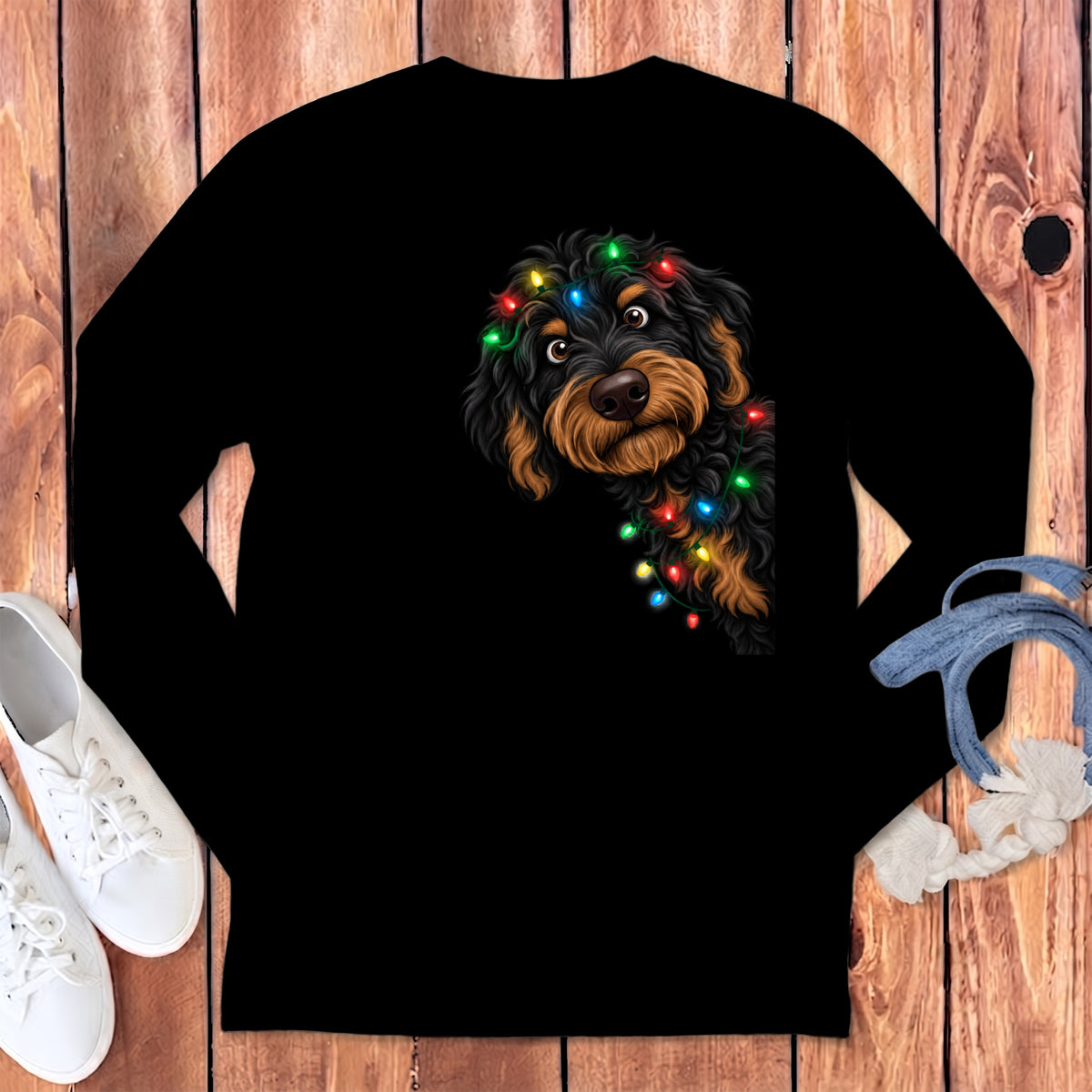 Black long-sleeve shirt with a brown dog peeking out, adorned with colorful Christmas lights.