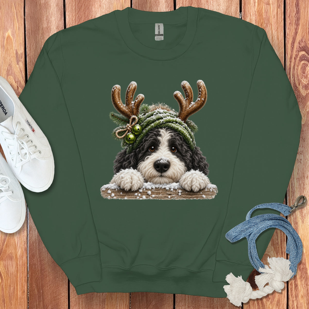 Green sweatshirt with a fluffy dog wearing antlers and a winter hat.
