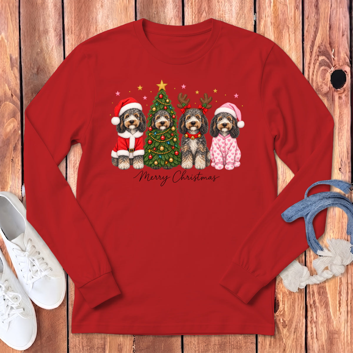A red long-sleeve shirt with a Christmas graphic of four dogs, a decorated tree, and Merry Christmas text.