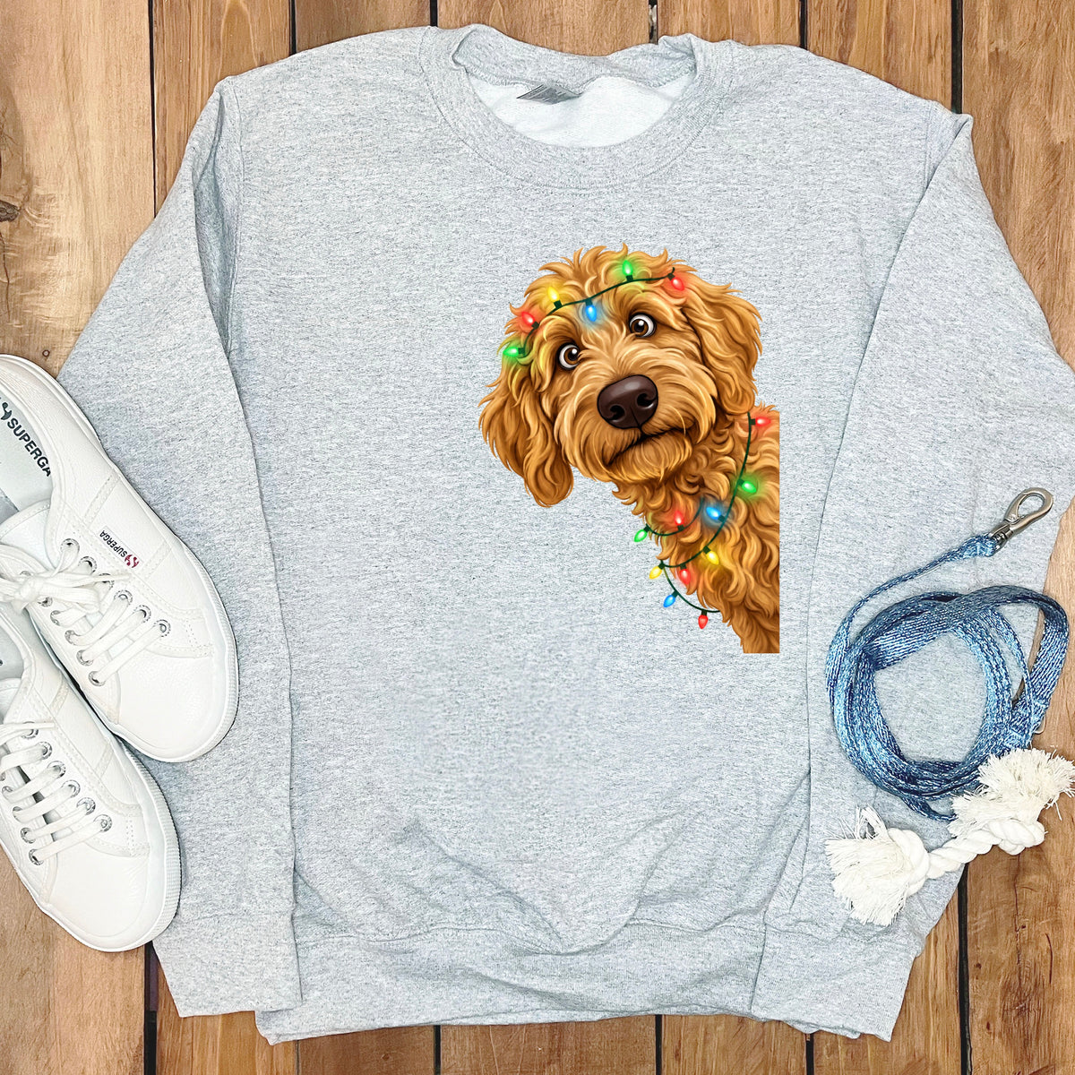 Light gray crewneck sweatshirt with a doodle dog wearing Christmas lights graphic.