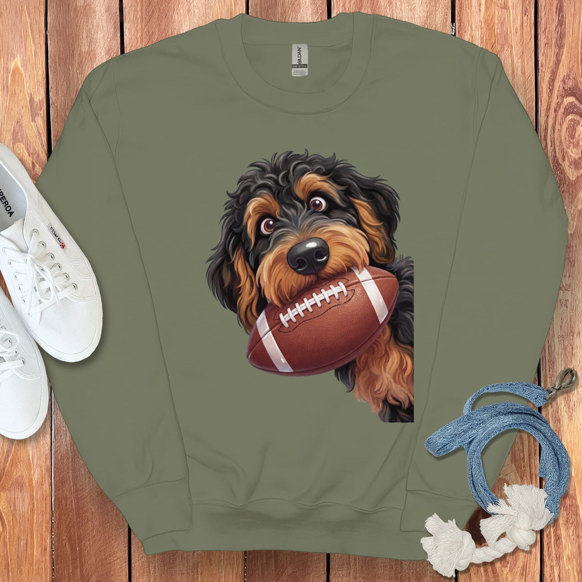 Olive green sweatshirt with a graphic of a dog holding a football.