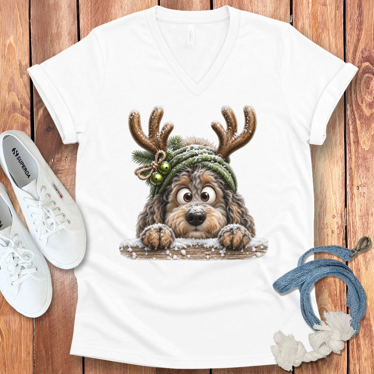 White v-neck t-shirt with a cartoon dog wearing reindeer antlers and a green hat.