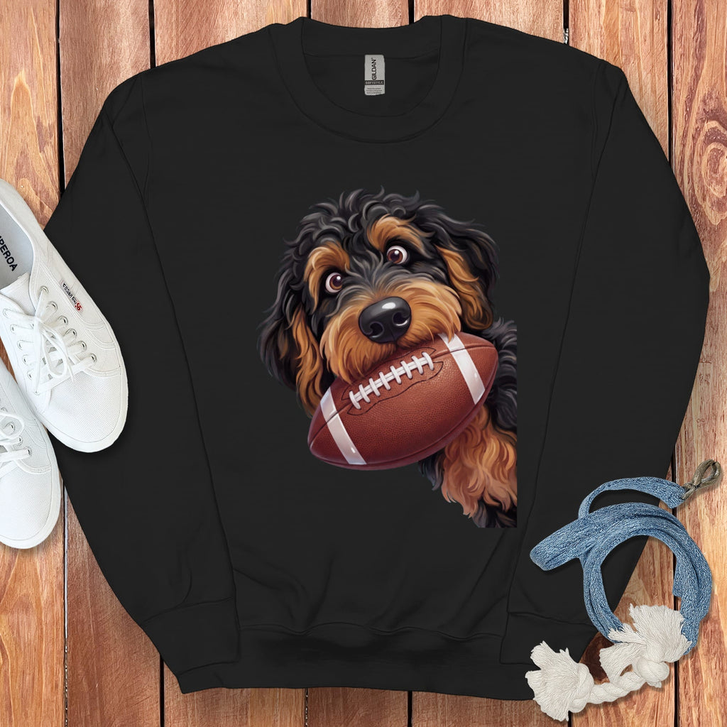 Black crewneck sweatshirt with a doodle dog graphic holding a football.