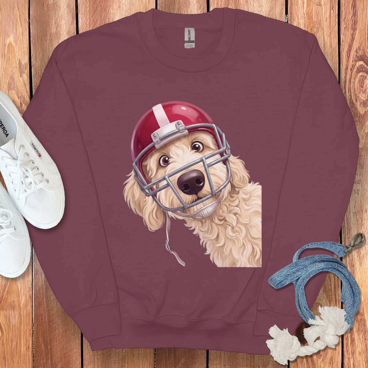 Maroon sweatshirt with a cream doodle dog wearing a red football helmet.