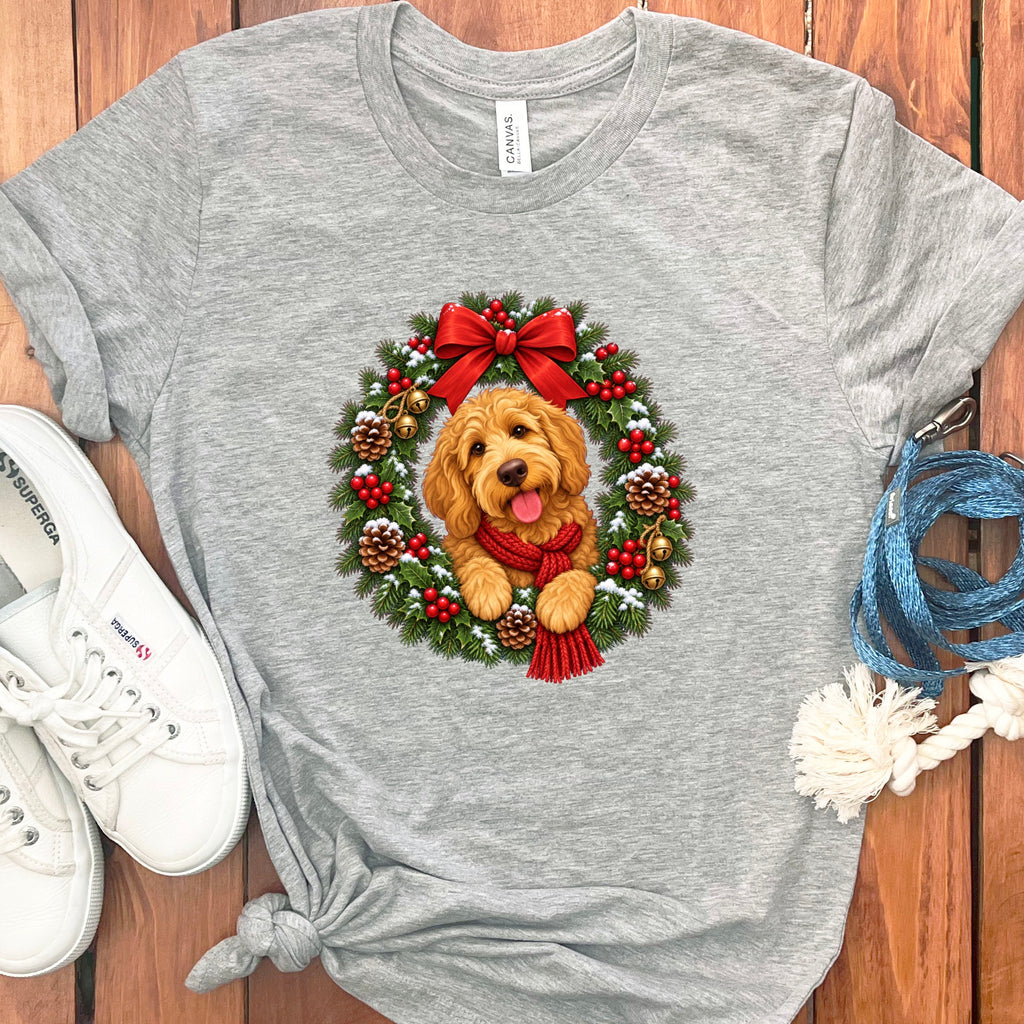 Heather gray t-shirt featuring a doodle dog graphic inside a Christmas wreath, accompanied by white sneakers and a blue leash.