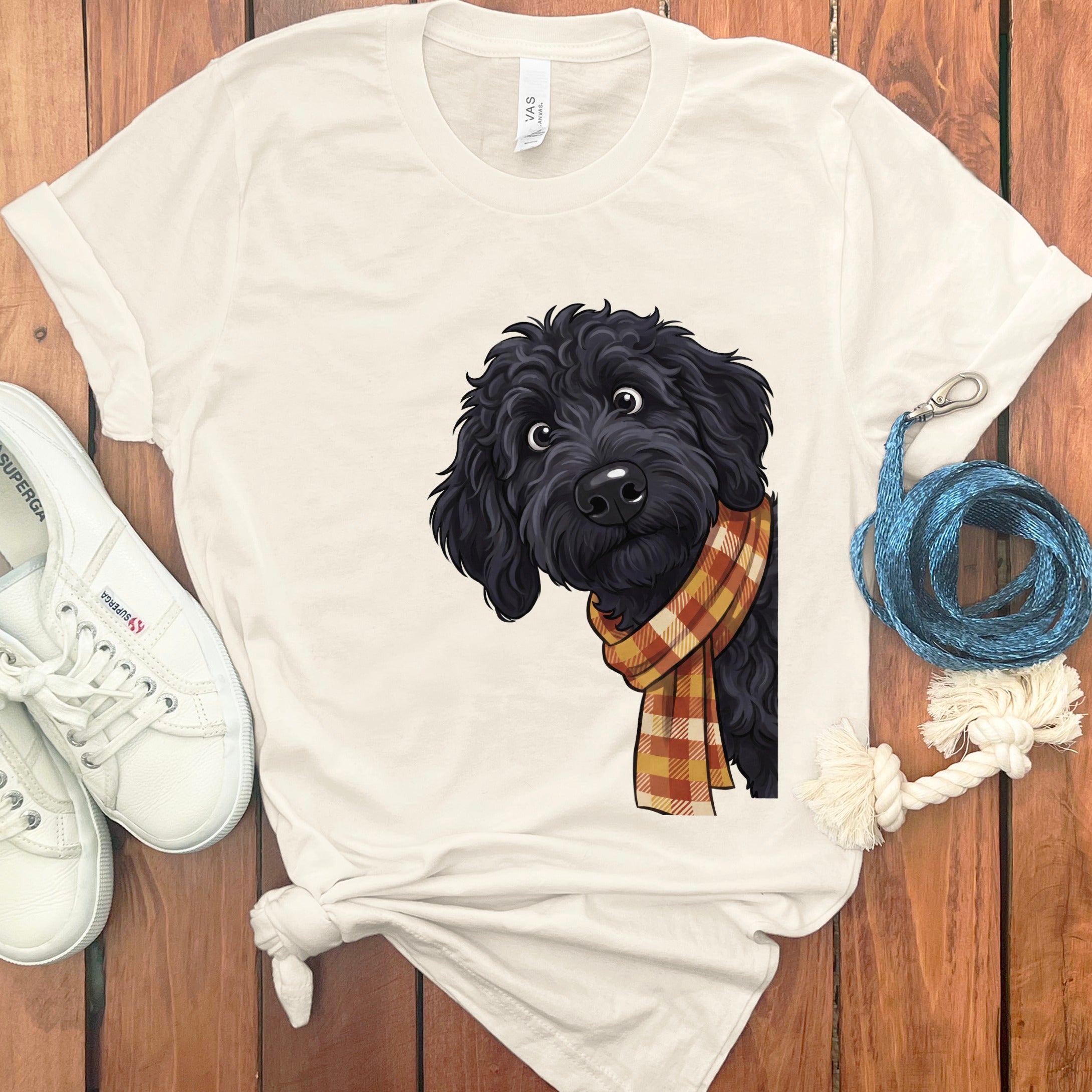 T-shirt with illustration of a black dog wearing a plaid scarf.