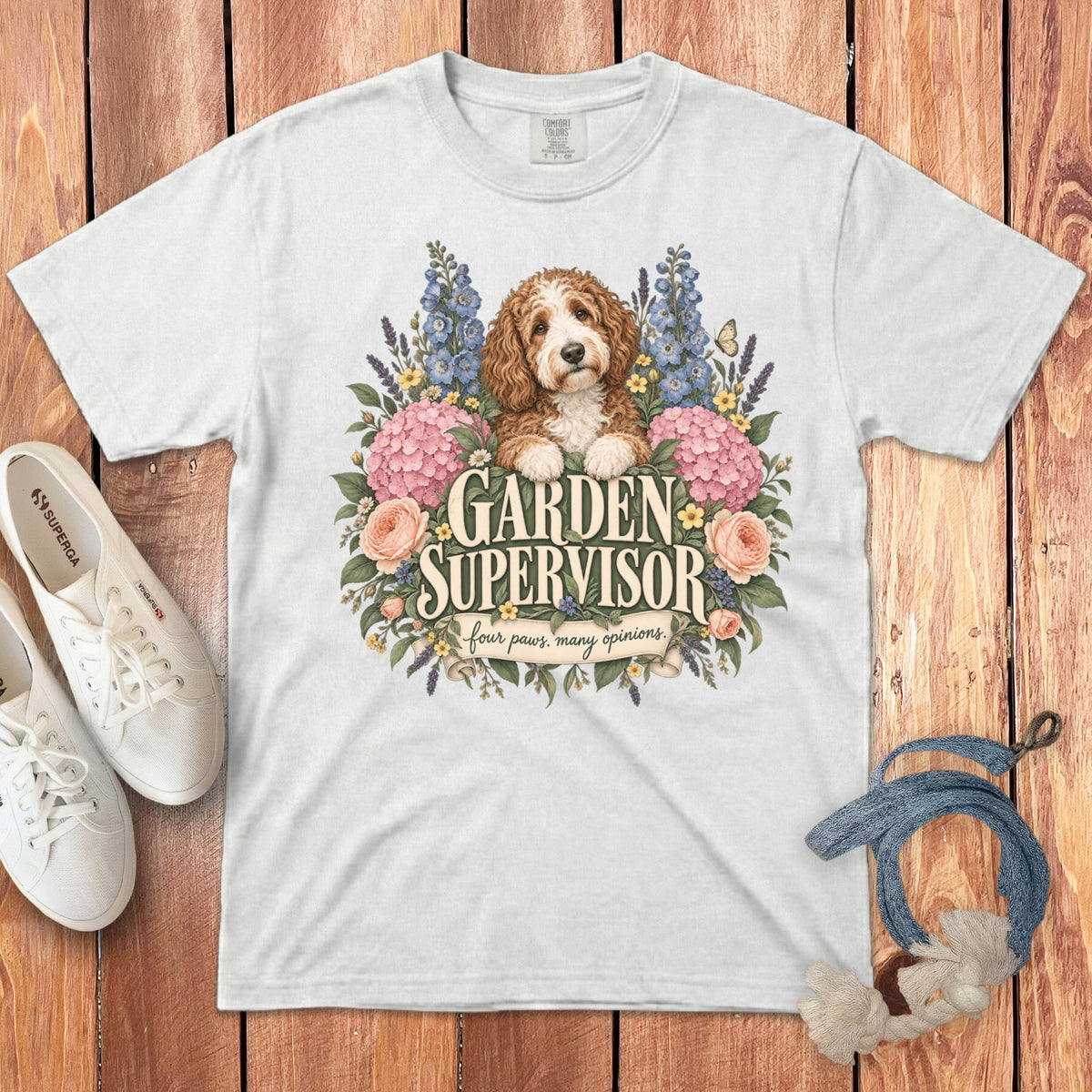 A white t-shirt featuring a doodle dog surrounded by flowers and the text Garden Supervisor.