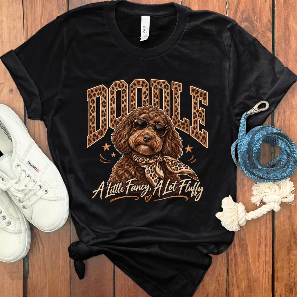 Black t-shirt with a doodle wearing sunglasses and a leopard print scarf. Text reads "Doodle A Little Fancy, A Lot Fluffy".