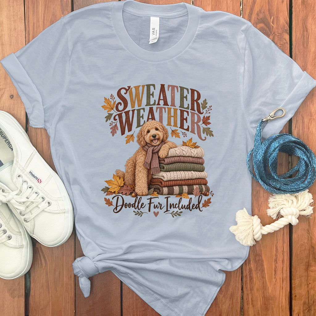 Light blue t-shirt with a doodle, sweaters, and text saying "Sweater Weather Doodle Fur Included."
