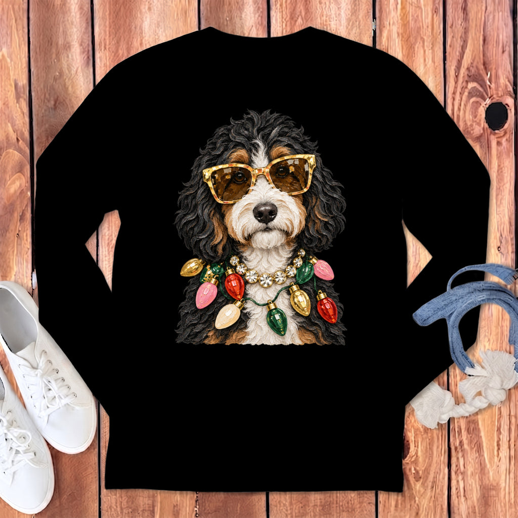 Bernedoodle wearing sunglasses and a Christmas light necklace on a black shirt.