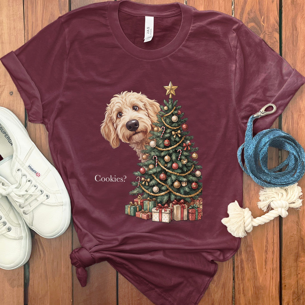 Goldendoodle peeking out from behind a Christmas tree with gifts and text.