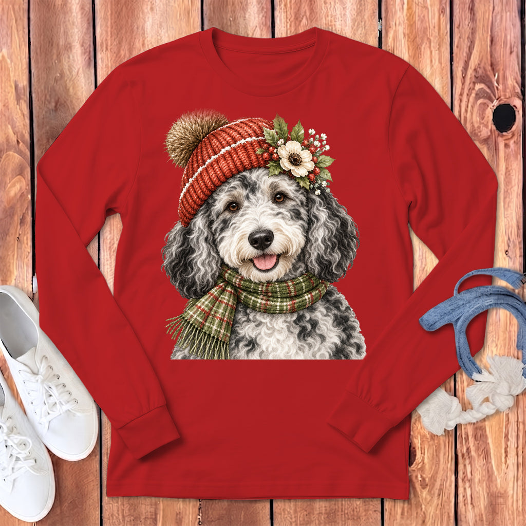 Black and white doodle dog wearing a red knit hat and green plaid scarf.