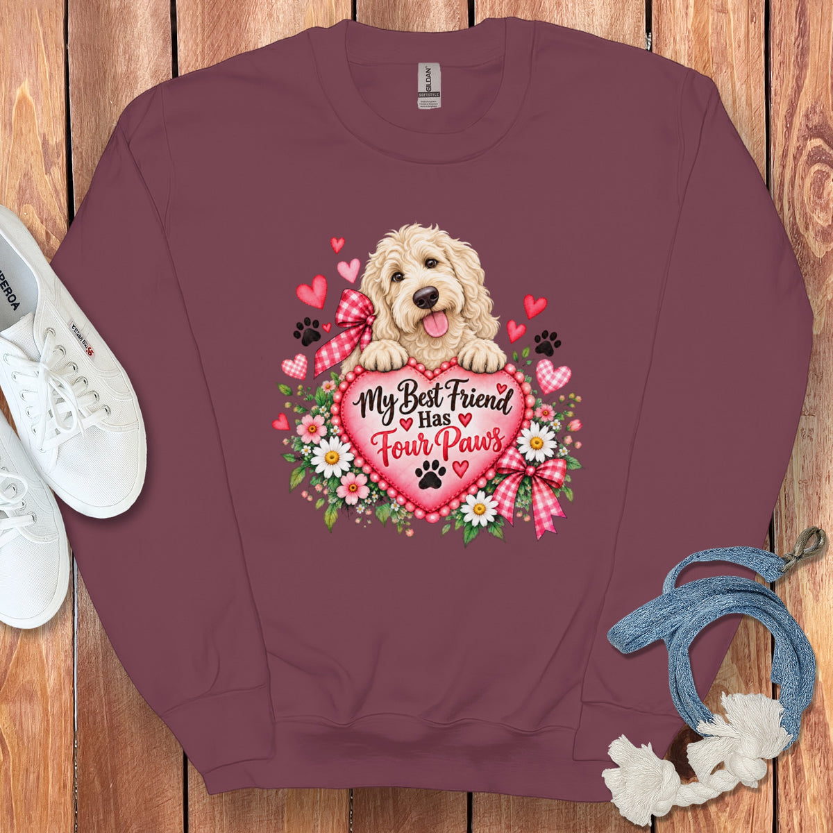Maroon crewneck sweatshirt featuring a doodle dog graphic with hearts, flowers, and the text My Best Friend Has Four Paws.