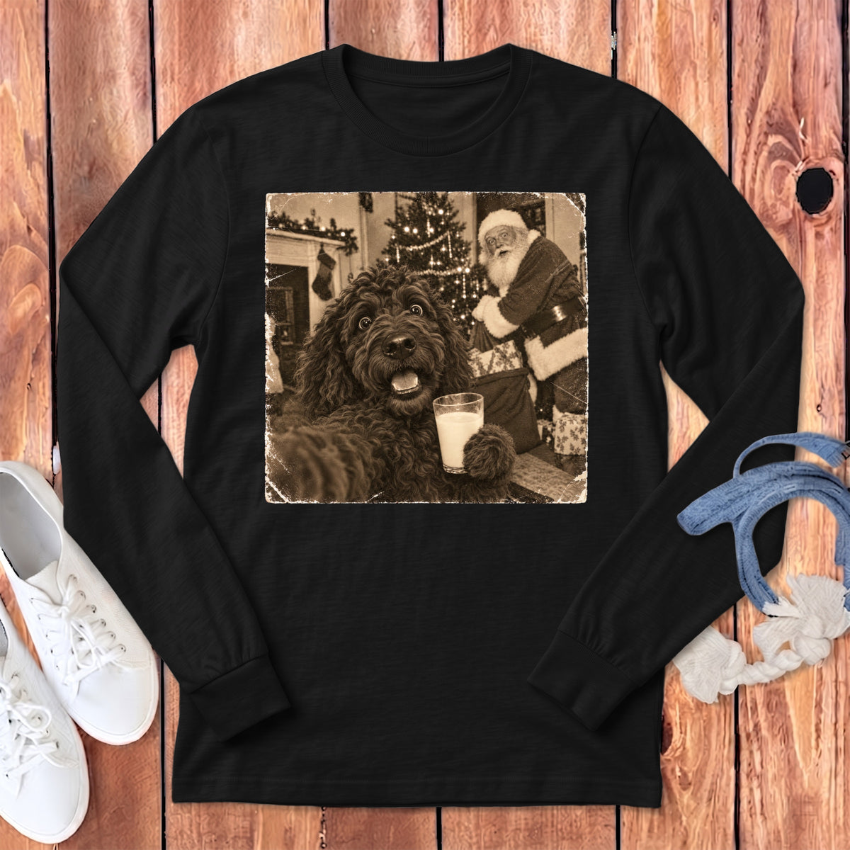 A black long-sleeve t-shirt featuring a graphic of a dog holding a glass of milk next to Santa Claus.