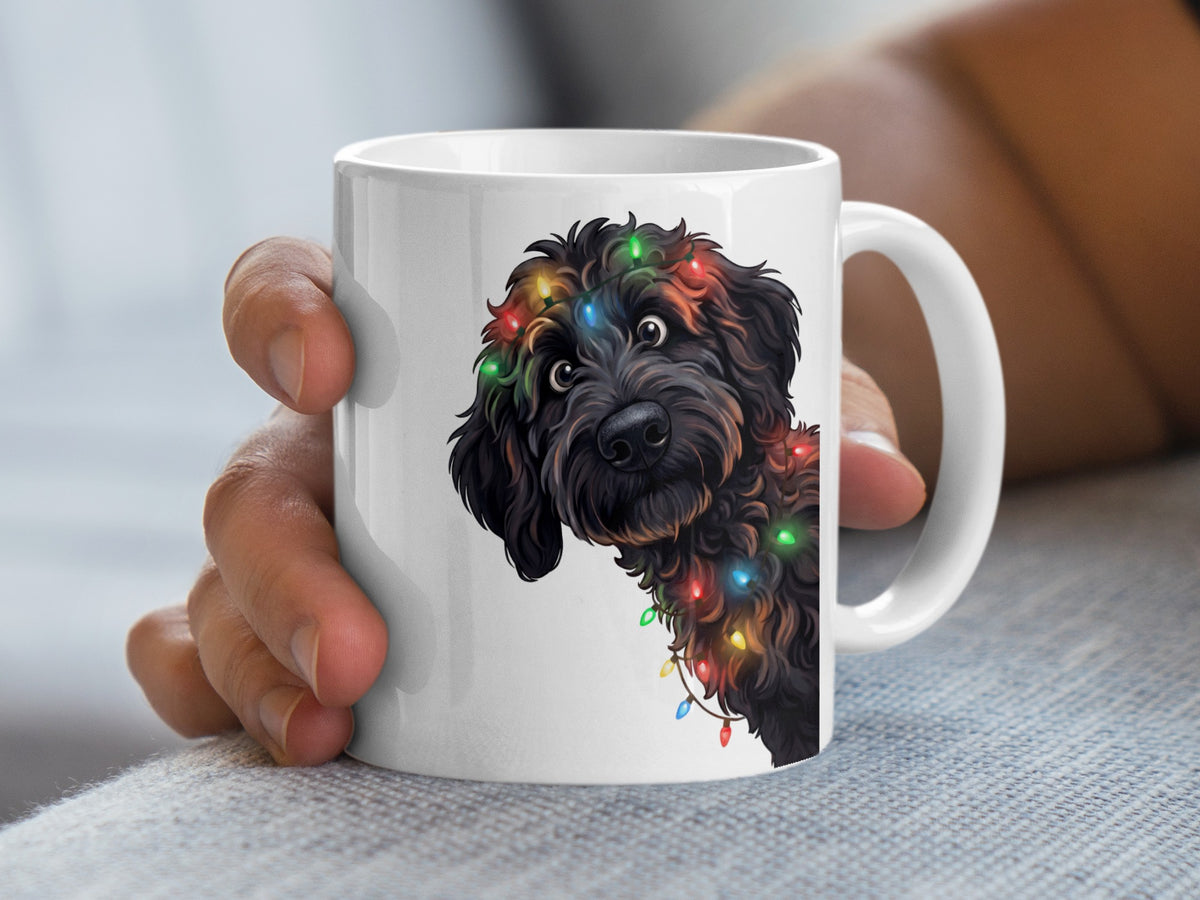White mug with illustration of black dog tangled in colorful Christmas lights.