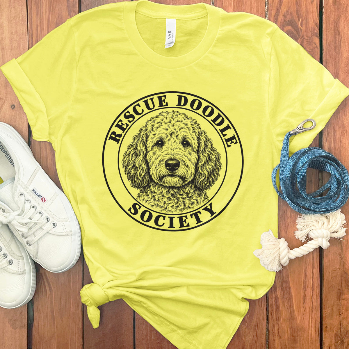 Yellow t-shirt with black text and doodle dog illustration: Rescue Doodle Society.