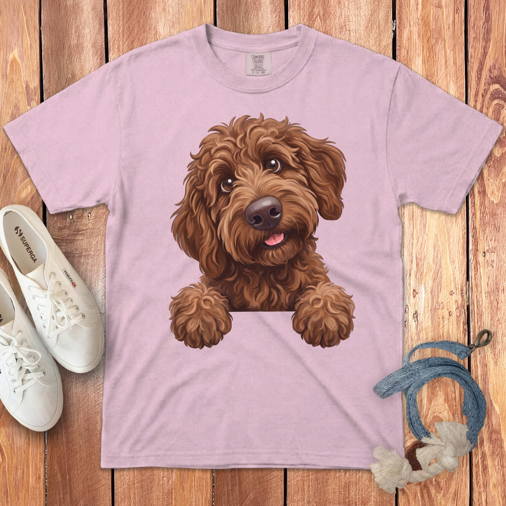 Pink t-shirt with a drawing of a brown fluffy dog peeking over the collar.