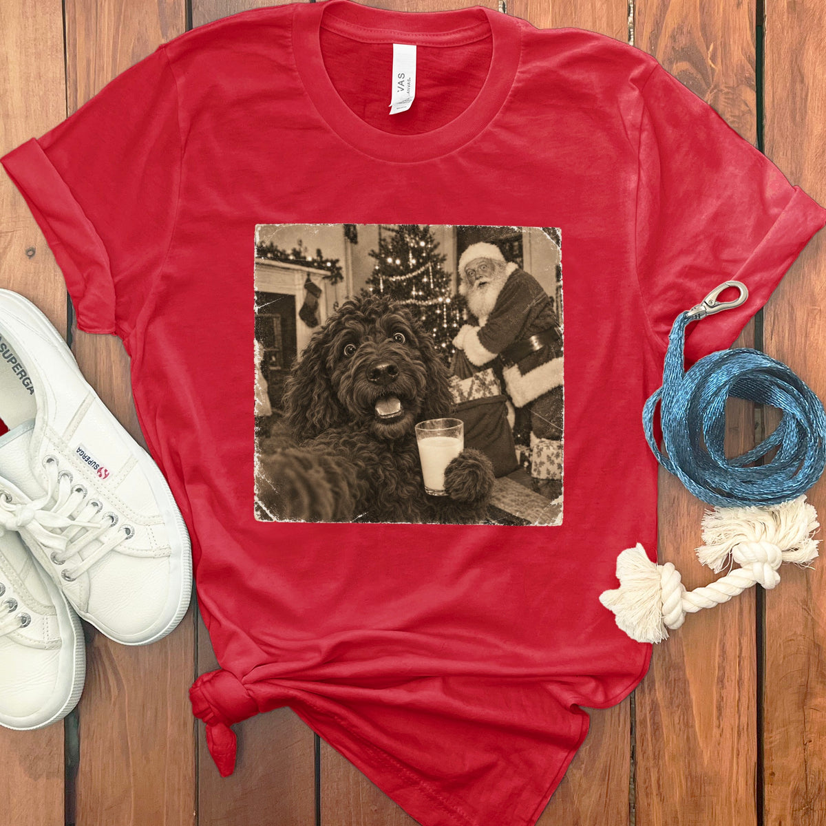 A red crewneck t-shirt featuring a vintage black-and-white graphic of a dog holding a glass of milk near Santa Claus.