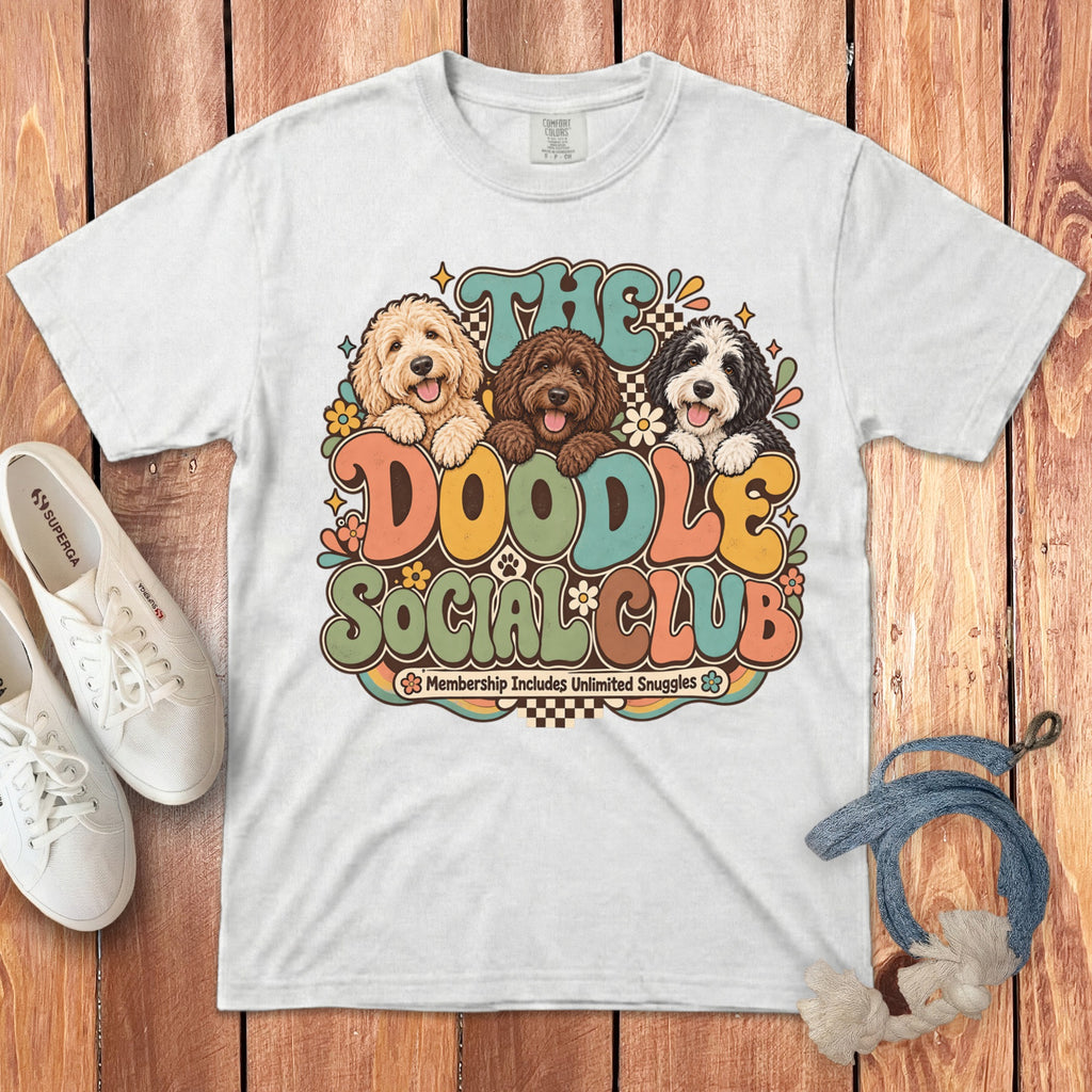 White t-shirt with graphic of three doodles and text "The Doodle Social Club Membership Includes Unlimited Snuggles".