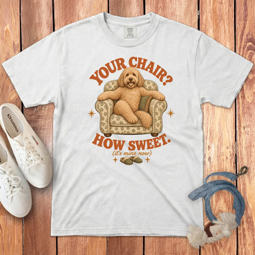 White t-shirt with a graphic of a fluffy dog sitting in an armchair and text reading Your Chair? How Sweet. (It's Mine Now).