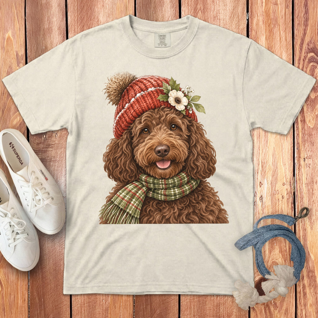 Cream t-shirt with a brown doodle dog wearing a red knitted hat and green scarf.