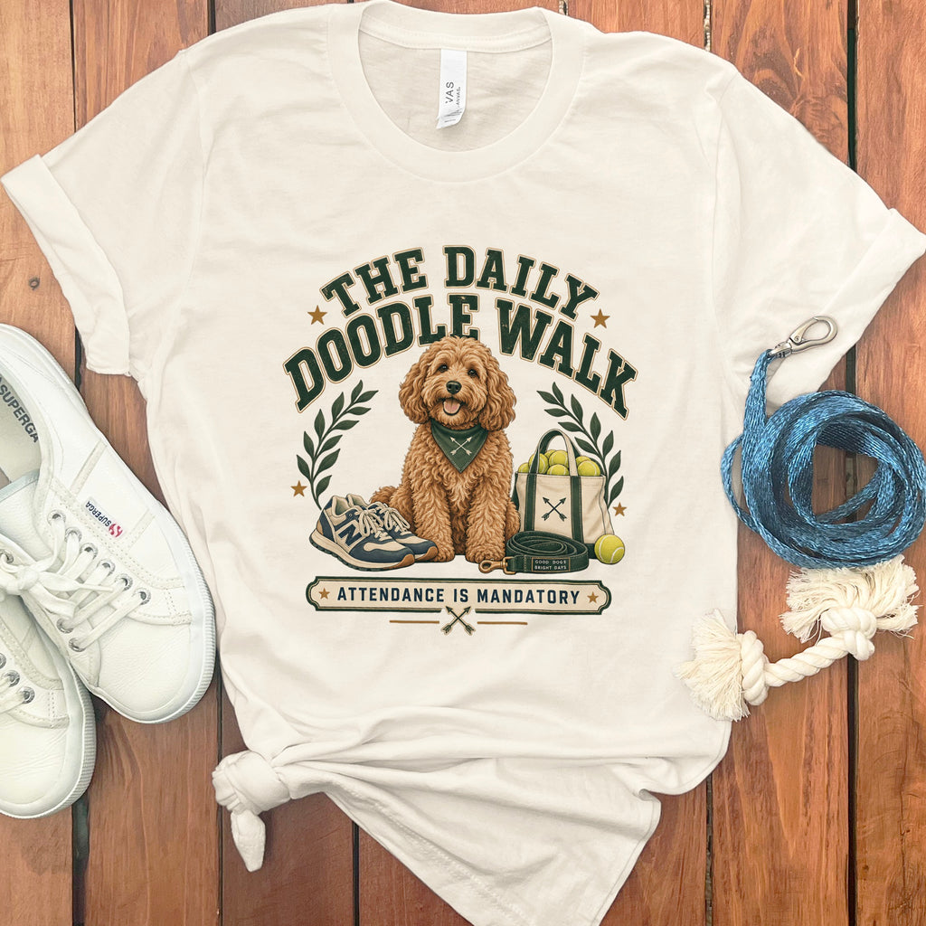 T-shirt graphic with doodle dog, leash, tennis balls, and "The Daily Doodle Walk" text.