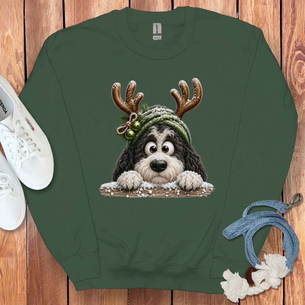 Green sweatshirt with a black and white dog wearing reindeer antlers and a green beanie.