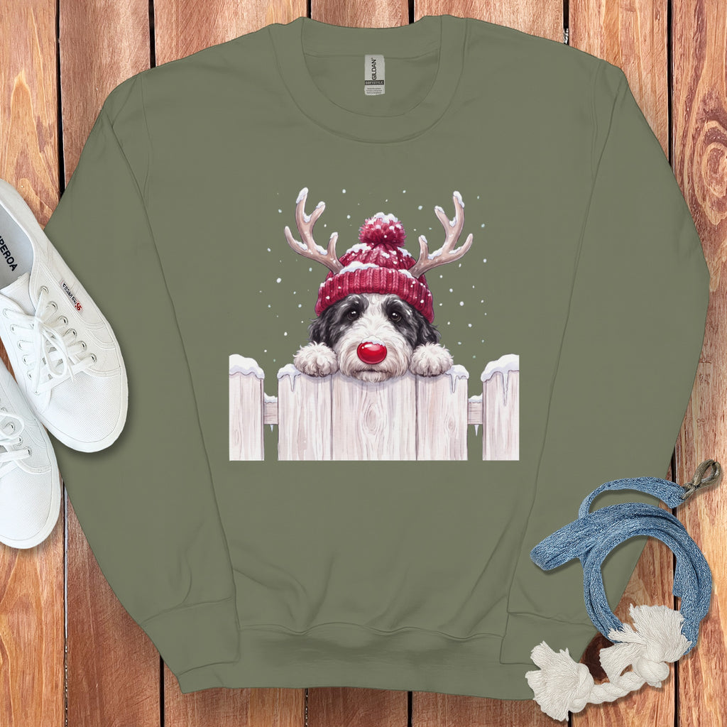 Crewneck sweatshirt with a black and white dog wearing a red knit hat and antlers.