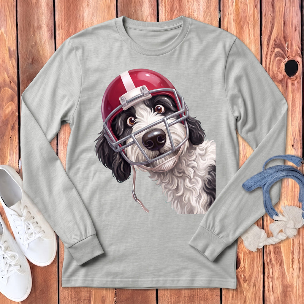 Dog wearing a red and white football helmet and face mask on a grey long-sleeve shirt.