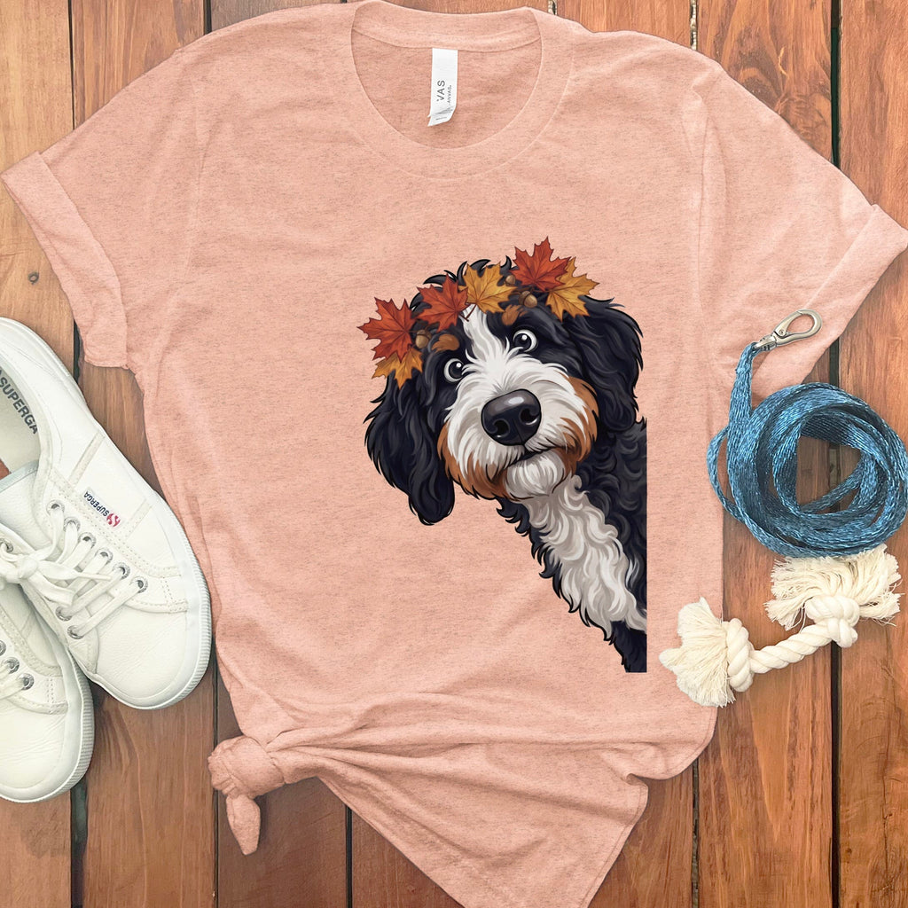 Bernese Mountain Dog puppy with autumn leaves crown on a peach t-shirt.