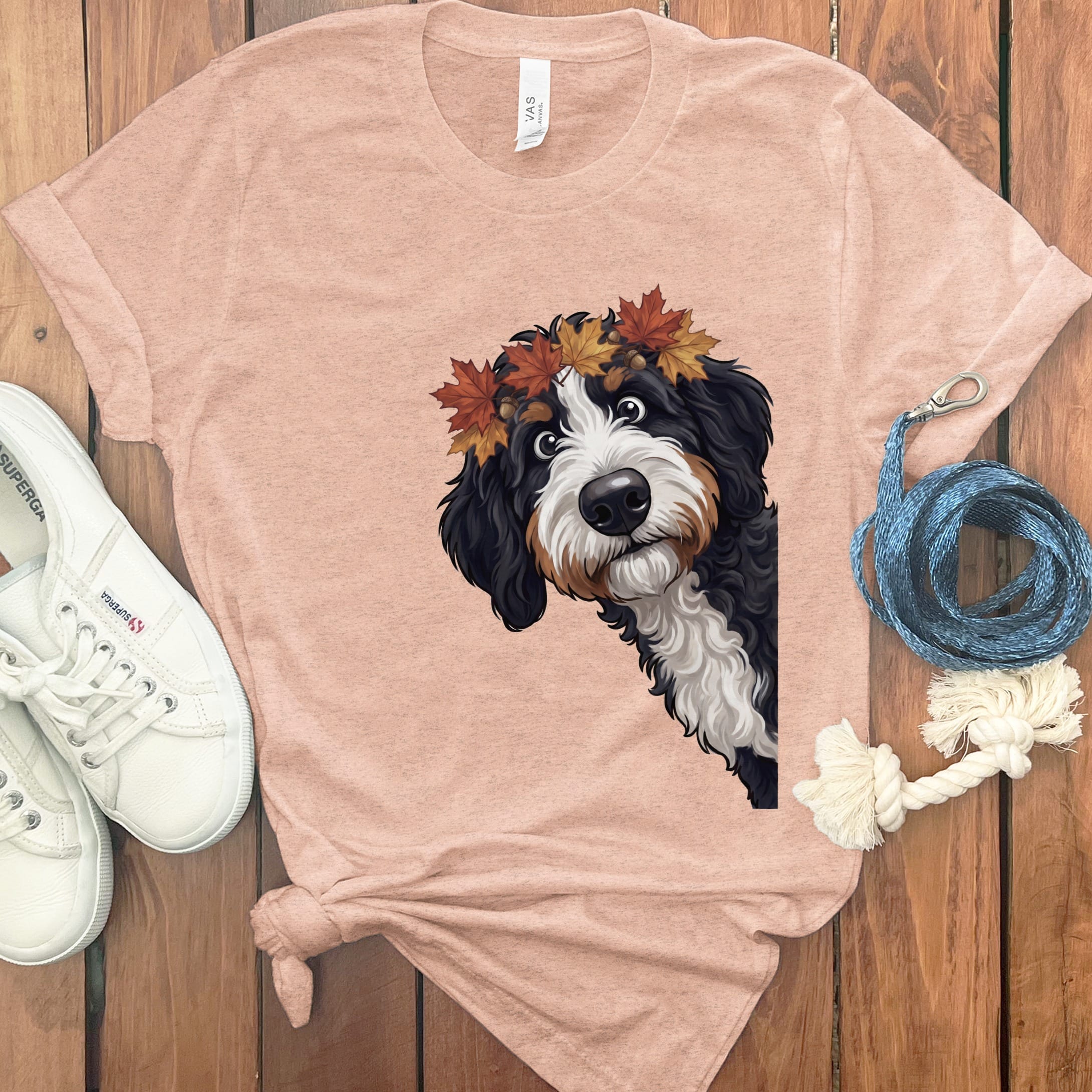 Bernese Mountain Dog puppy with autumn leaves crown on a peach t-shirt.