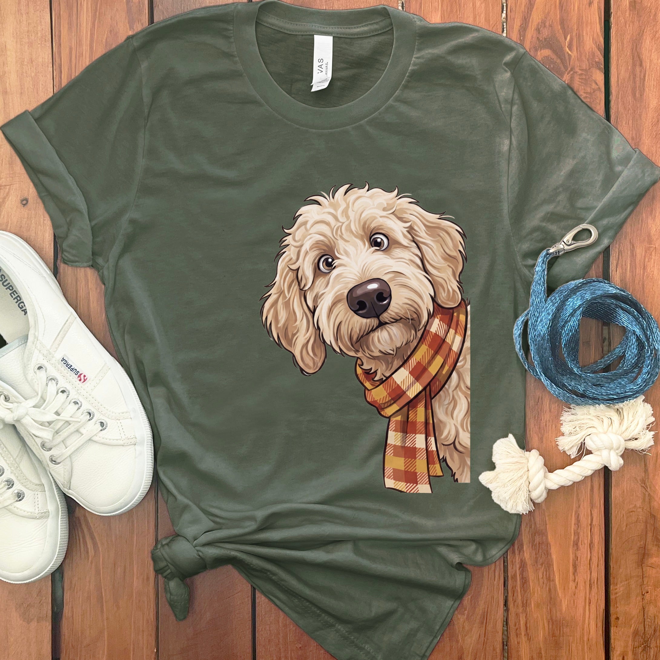 Olive green t-shirt with a doodle dog wearing a plaid scarf graphic.