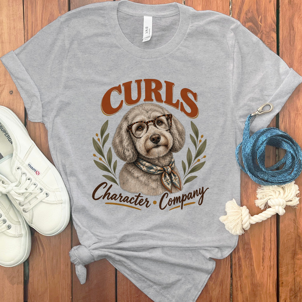 Grey t-shirt with a poodle wearing glasses and scarf, text says "Curls Character Company".