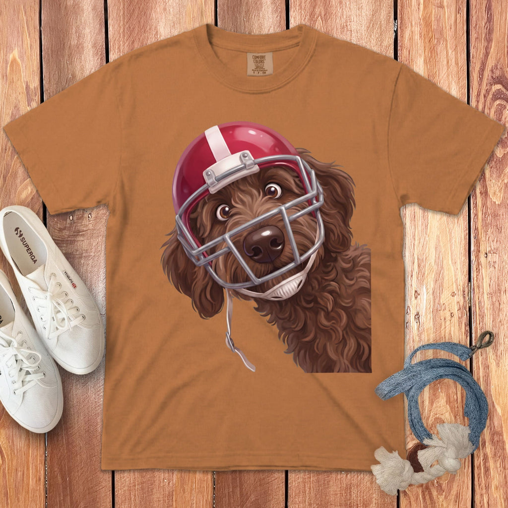 Brown doodle wearing a red football helmet on a tan t-shirt.