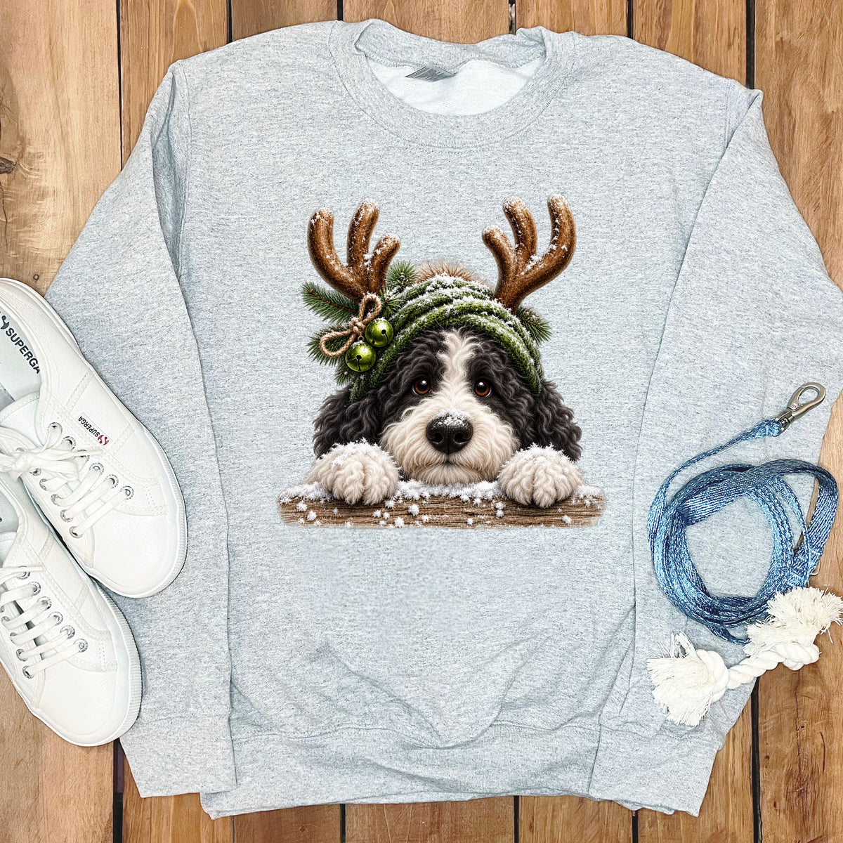 Light gray sweatshirt with a black and white dog wearing a green knit hat with antlers.