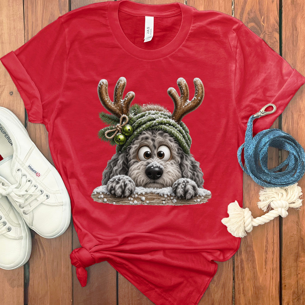 Red t-shirt with a cartoon dog wearing reindeer antlers and a green hat.