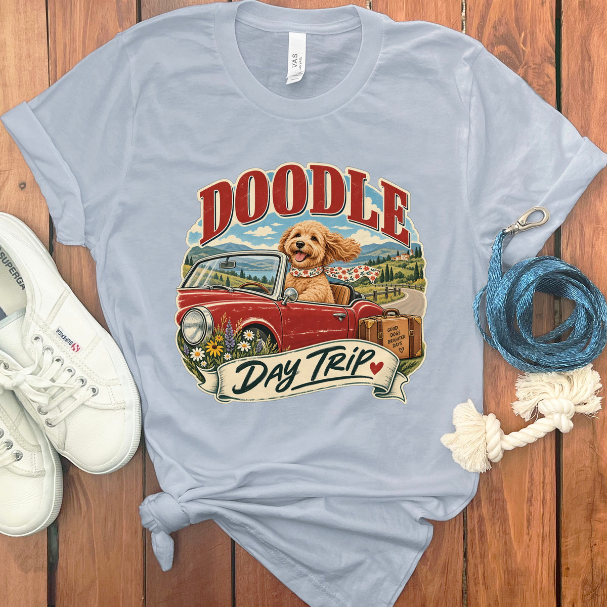Light blue t-shirt with doodle dog driving a red convertible, text "Doodle Day Trip".