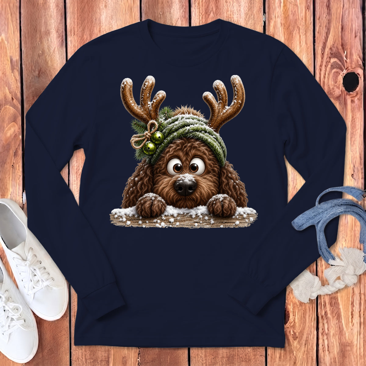 Brown dog wearing reindeer antlers and a green hat with bells on navy shirt.