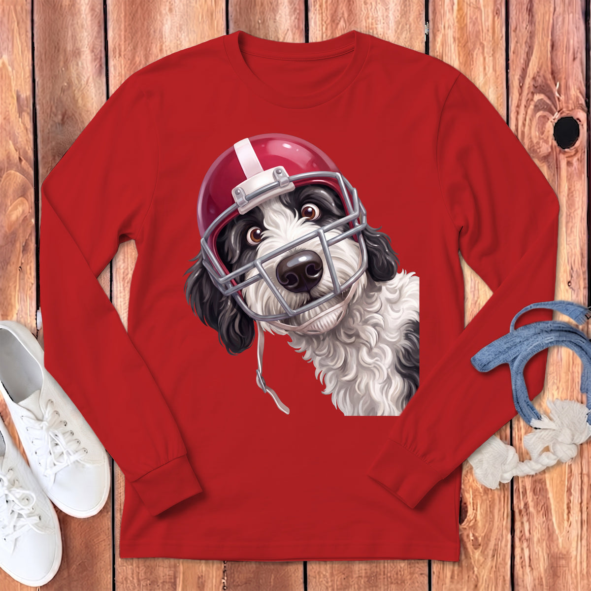Dog wearing a red and white football helmet on a red long-sleeved shirt.