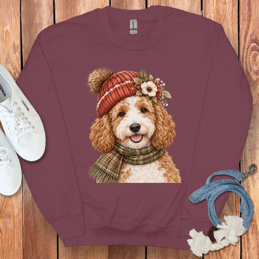 Maroon sweatshirt with a whimsical illustration of a golden doodle wearing a festive hat and scarf.
