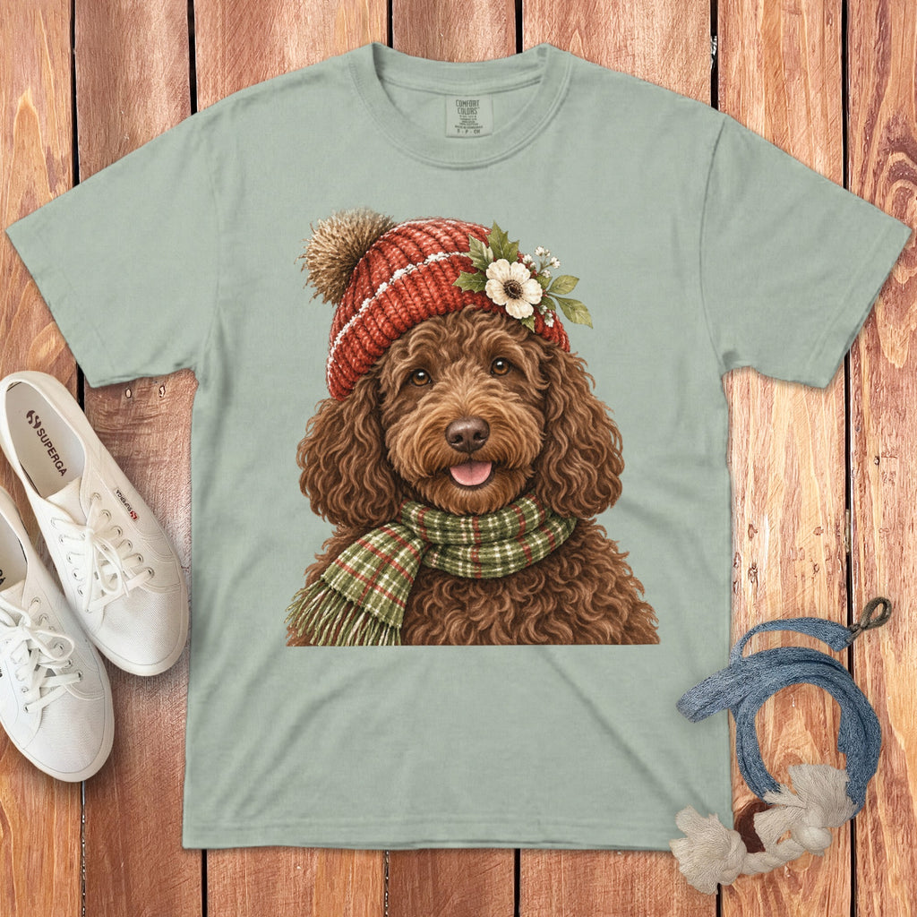 Brown doodle dog wearing a red pom-pom hat and green plaid scarf.