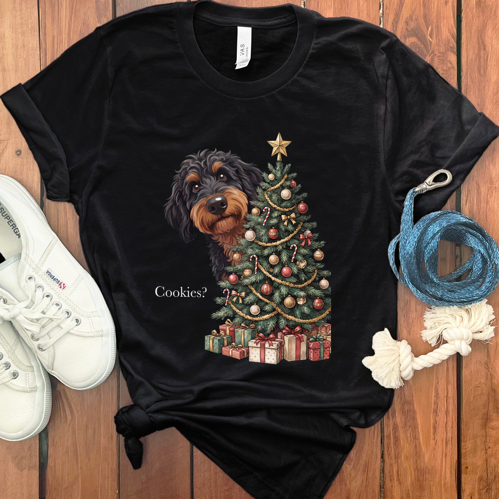 Black t-shirt with a dachshund peeking behind a Christmas tree with gifts.