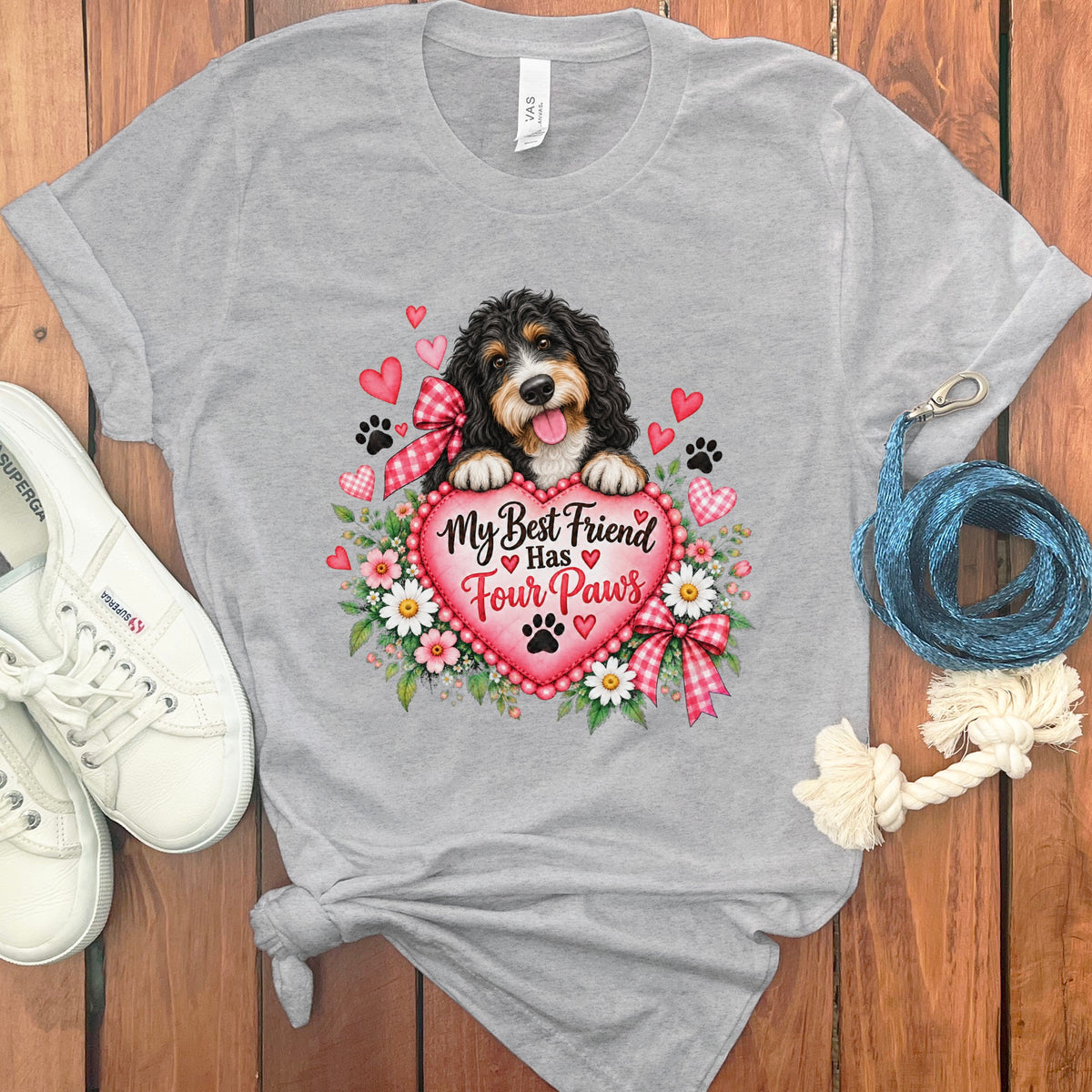 Heather gray t-shirt featuring a bernedoodle graphic, heart text reading My Best Friend Has Four Paws, white sneakers, and a blue leash.