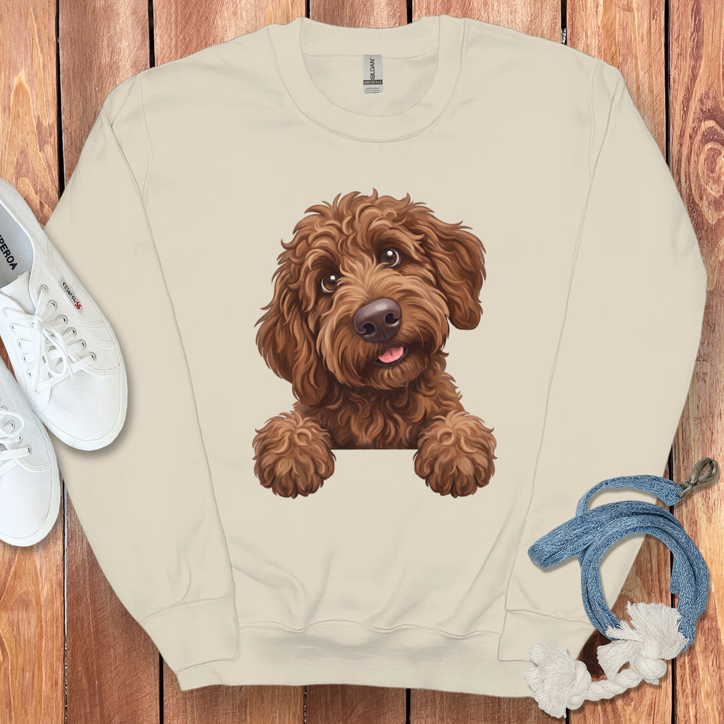 Cream sweatshirt with a watercolor illustration of a brown doodle dog peeking over.